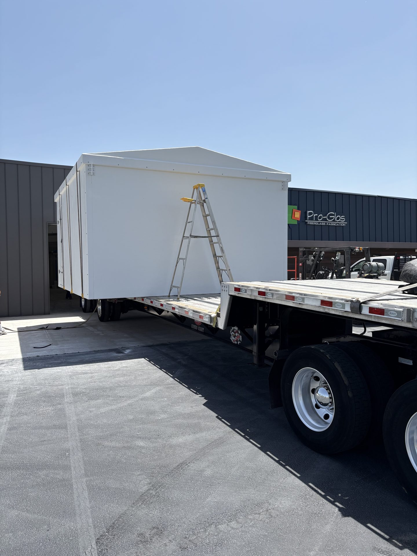Fiberglass shelter loaded on a flatbed trailer